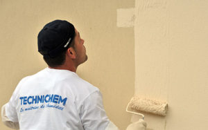 Homme qui applique la peinture sur mur extérieur